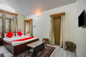 um quarto com uma cama com almofadas vermelhas e uma televisão em OYO Retro Residency em Durgāpur