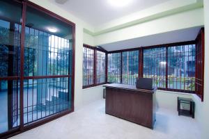 un bureau avec de grandes fenêtres et un bureau avec un ordinateur portable dans l'établissement OYO Retro Residency, à Durgapur