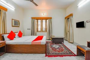 OYO Retro Residency في درغابور: غرفة نوم بسرير كبير ومخدات حمراء