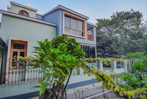 uma casa azul e branca com uma árvore em frente em OYO Retro Residency em Durgapur