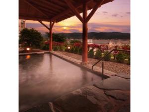 einen Pool mit Sonnenuntergang im Hintergrund in der Unterkunft Kesennuma Plaza Hotel - Vacation STAY 15381v in Kesennuma