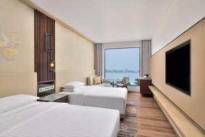 ゴーラクプルにあるCourtyard by Marriott Gorakhpurのベッド2台、薄型テレビが備わるホテルルームです。