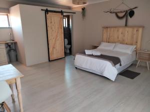 um quarto com uma cama grande e uma cabeceira em madeira em Rustic Stone Lodge em Thabazimbi