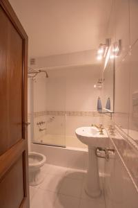 a bathroom with a sink and a tub and a toilet at El Misti Coliving Obelisco in Buenos Aires