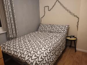 a bed with a black and white comforter in a room at Room Wollanton Park Beeston near East Midlands Conference Centre train station tram stop in Nottingham