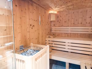 a sauna with wooden paneled walls and a tub at SportLodge BIKE SUITE - AlpenLuxus Collection in Kleinboden