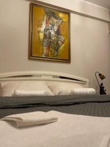 a bedroom with a bed with a painting on the wall at Art-Inspired, Cozy Apartment in Vračar (historical)