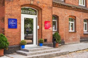 a red brick building with a white door and stairs at Queens Park Hotel in Berlin