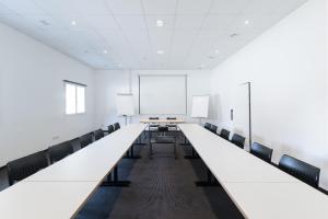 una sala de conferencias vacía con mesas y sillas largas en Motel Gottardo Sud, en Piotta