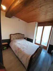 ein Schlafzimmer mit einem Bett in einem Zimmer mit Holzdecken in der Unterkunft Gîte Napoléon in Dienville