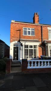 a red brick house with a white front door at Sandy Shores Holiday Home in Cleethorpes