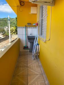 a bathroom with a sink and a yellow wall at Apartamento cachoeira in Florianópolis