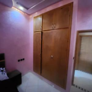 łazienka z drewnianą szafką w różowej ścianie w obiekcie B 12 apartment w Fezie