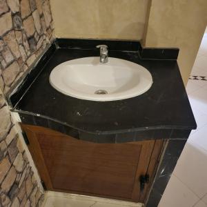 - Baño con lavabo y encimera negra en B 12 apartment, en Fez