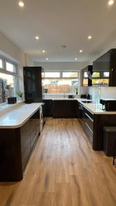 a kitchen with wooden floors and a large kitchen with counters at Sandy Shores Holiday Home - Great for family stays and contractors in Cleethorpes