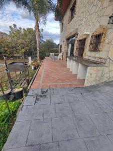une terrasse à l'extérieur d'un bâtiment avec un banc dans l'établissement Casa Rural Sierra de las Nieves 2, à Tolox