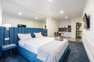 伊萬諾弗蘭克威斯克的住宿－ApartReserve Avtorskiy，一间卧室配有一张大床和蓝色床头板