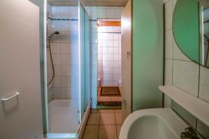 a bathroom with a shower and a tub and a sink at Les Bucherons in Awenne