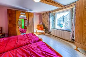 a bedroom with a red bed and a window at Les Bucherons in Awenne