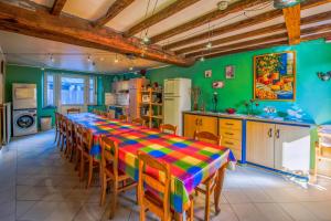 a kitchen with a long table with chairs and a refrigerator at Les Bucherons in Awenne