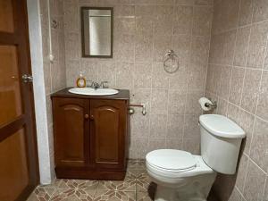 a bathroom with a toilet and a sink at Casa Robles - Your Stay Near Airport in Managua