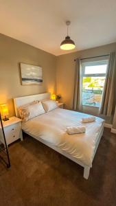 a bedroom with a large white bed with a window at Sandy Shores Holiday Home in Cleethorpes