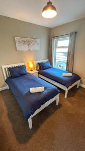 two beds in a room with a window at Sandy Shores Holiday Home - Great for family stays and contractors in Cleethorpes