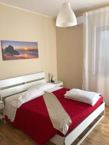 Moon River Guest House في بيسكارا: غرفة نوم بسرير وبطانية حمراء