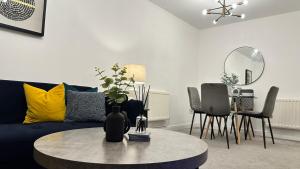 a living room with a blue couch and a table at Superb & Stylish - Free Parking - Gated Community in Hatfield