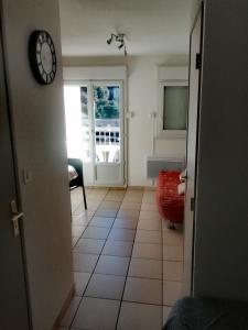 una habitación con un reloj en la pared junto a una puerta en Appartement, en Lamalou-les-Bains