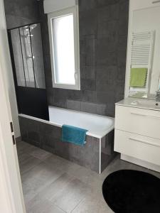 een badkamer met een bad en een wastafel bij Mi Casa in Achères