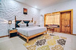 a bedroom with a king sized bed and a table at Mandaal Corbett in Rāmnagar
