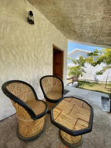 2 sillas y una mesa en un porche en Mandaal Corbett, en Rāmnagar