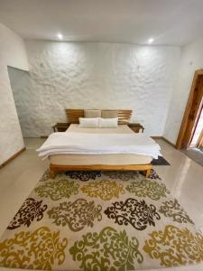 a bedroom with a bed and a large rug at Mandaal Corbett in Rāmnagar