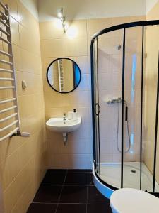 a bathroom with a shower and a sink at Pokoje Gościnne Strumykowa in Lublin