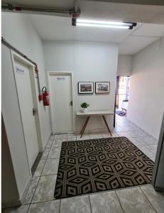 a hallway with two doors and a rug at Cantinho da Vesperata - Centro histórico de Diamantina in Diamantina