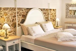 a bedroom with a large bed with two lamps on tables at Hotel La Corte Del Sole in Noto