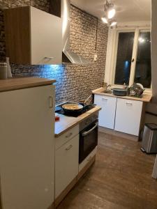 a kitchen with white cabinets and a stove top oven at Ferienhaus Sommer Linden in Deyelsdorf