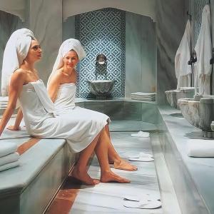 two women sitting on the edge of a bath tub at Luxury Apartment POOL SPA GYM 1+1 in Antalya