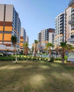 un parc avec des palmiers en face de grands bâtiments dans l'établissement Luxury Apartment POOL SPA GYM 1+1, à Antalya