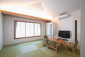 a living room with a table and chairs and a television at KyotoGosyonishi - Vacation STAY 23009v in Kyoto