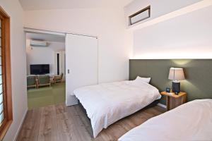 a bedroom with a large white bed and a television at KyotoGosyonishi - Vacation STAY 23009v in Kyoto