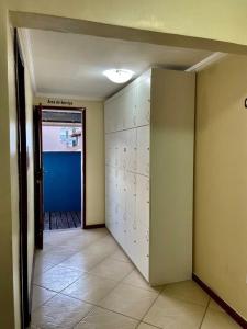 um quarto vazio com um corredor com uma porta e um quarto com uma parede em Prédio Atalaia - Praia Grande Arraial do Cabo em Arraial do Cabo