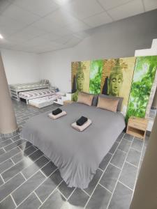 a bedroom with a large bed with two green faces on the wall at Casa Rural Sierra de las Nieves 2 in Tolox