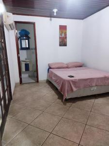 1 dormitorio con cama y espejo en Suíte Prainha, en Río de Janeiro