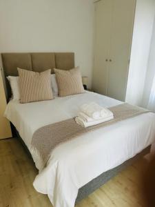 Una cama blanca con dos toallas encima. en 3-Bedrooms Apartment in Bushmill Amorosa, en Roodepoort