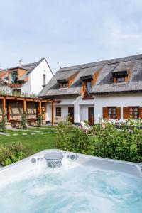 an outdoor hot tub in front of a house at Pipitér Rooms & More in Szigliget