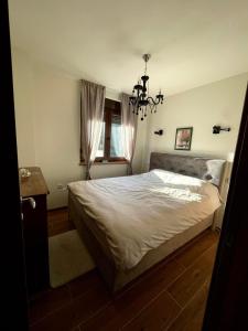 a bedroom with a large bed and a chandelier at Golden Gondola Tornik in Zlatibor