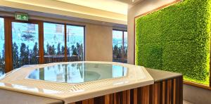 Una bañera de hidromasaje en una habitación con una pared verde. en VIP Apartamenty Zakopianskie, en Zakopane