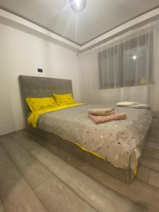 a bedroom with a bed with yellow pillows and a window at Apartament UltraLux cu 3 camere in Craiova
